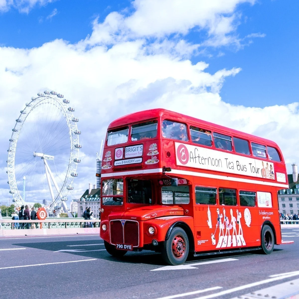 A vintage red Routemaster double decker bus on a bridge over the Thames, with the London Eye in the background. 