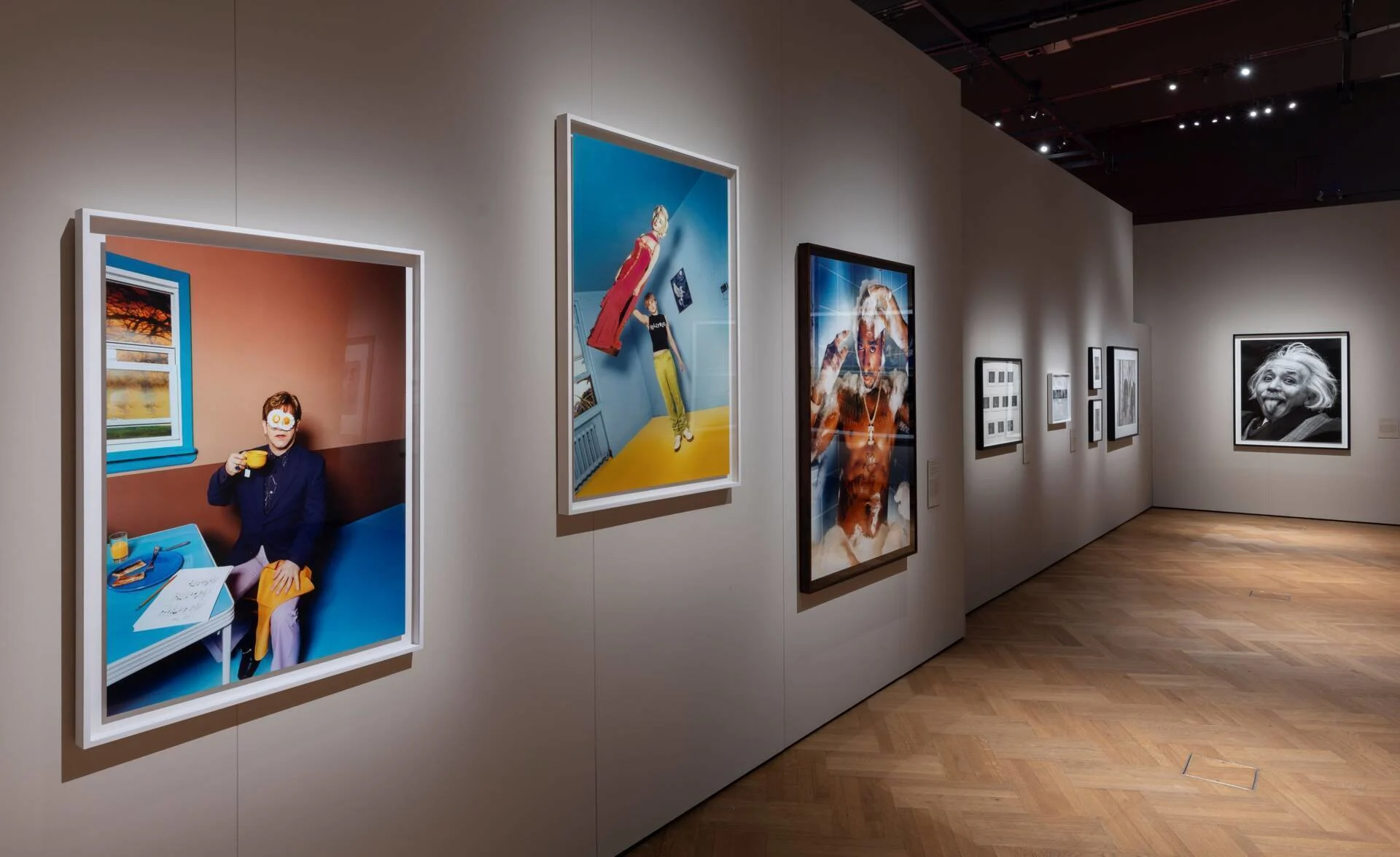 A range of large framed photographs in a spacious art gallery.