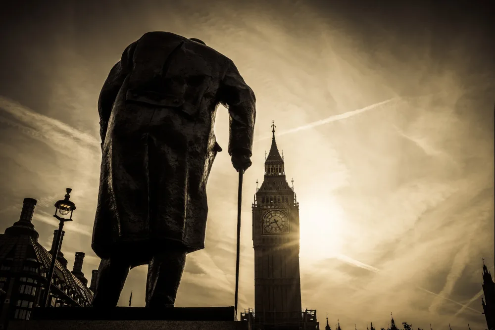 Sepia coloured image of a statue of Winston Churchill seem from behind, with Big Ben in the background. 