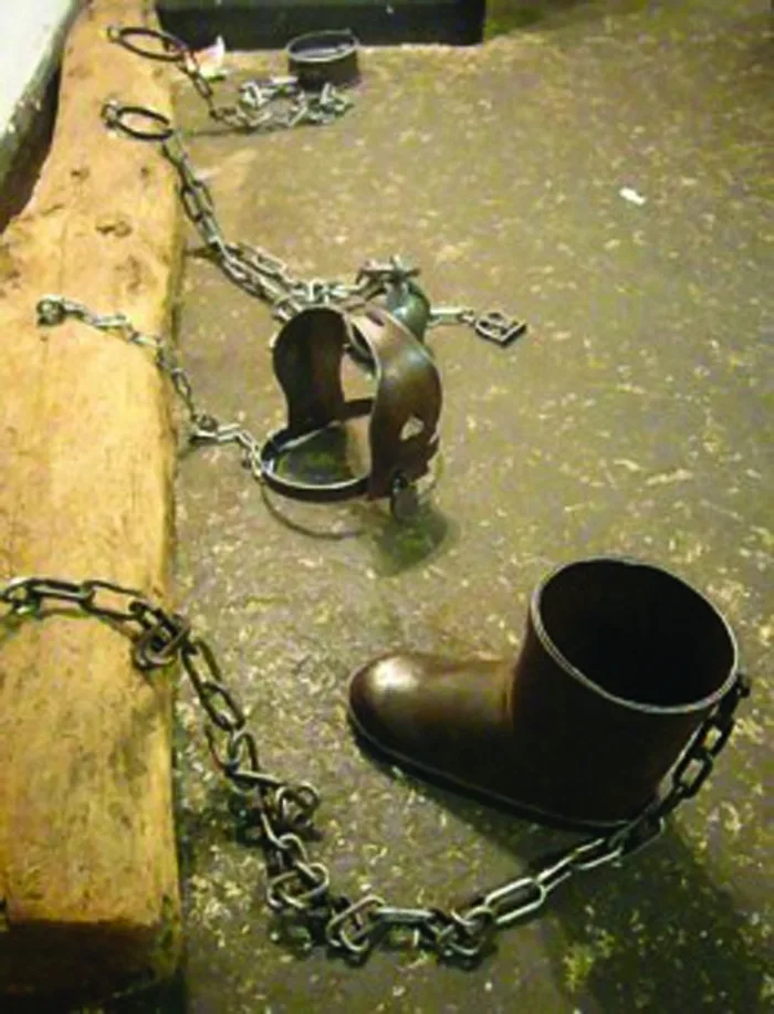 Chains and manacles on a bare floor. 