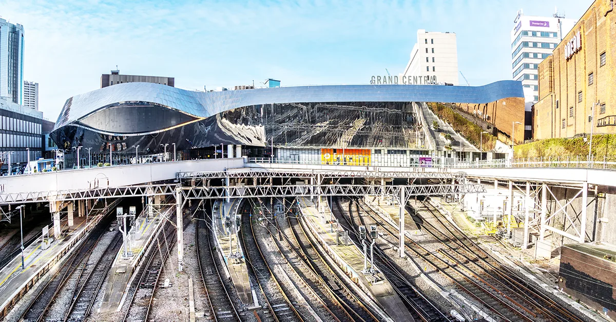 Aerial view of Birmingham New Street Station and Grand Central shopping centre with multiple railway tracks below.