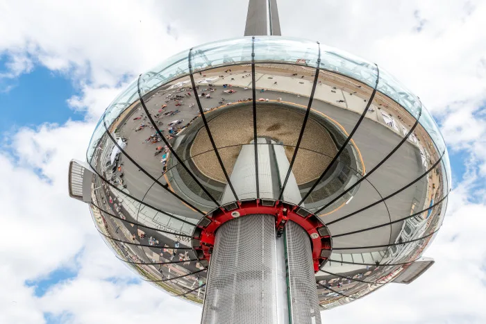 Observation tower sits in the sky with a reflection of the crowd below