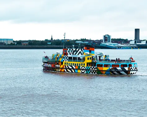 A brightly coloured passenger ferry crossing a calm river.
