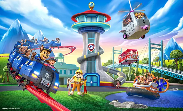 PAW Patrol-themed theme park with characters, rides, a lookout tower, helicopter, and roller coaster under a bright blue sky.