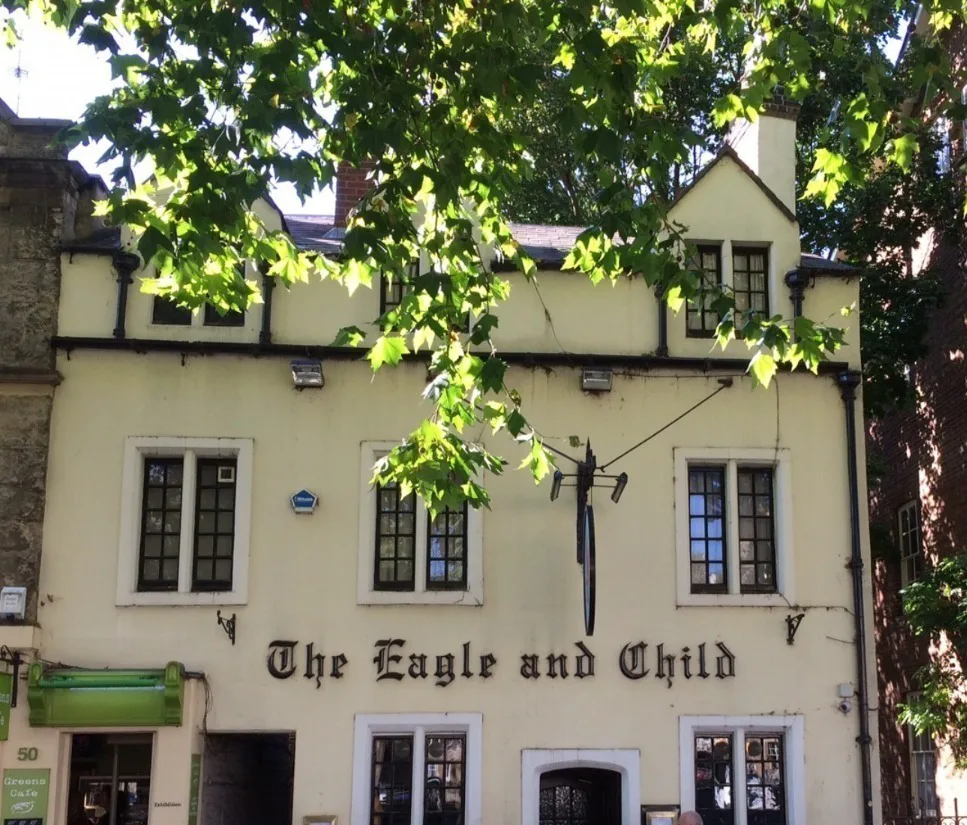 The exterior of a historic pub with letters on the wall spelling: The Eagle and Child.