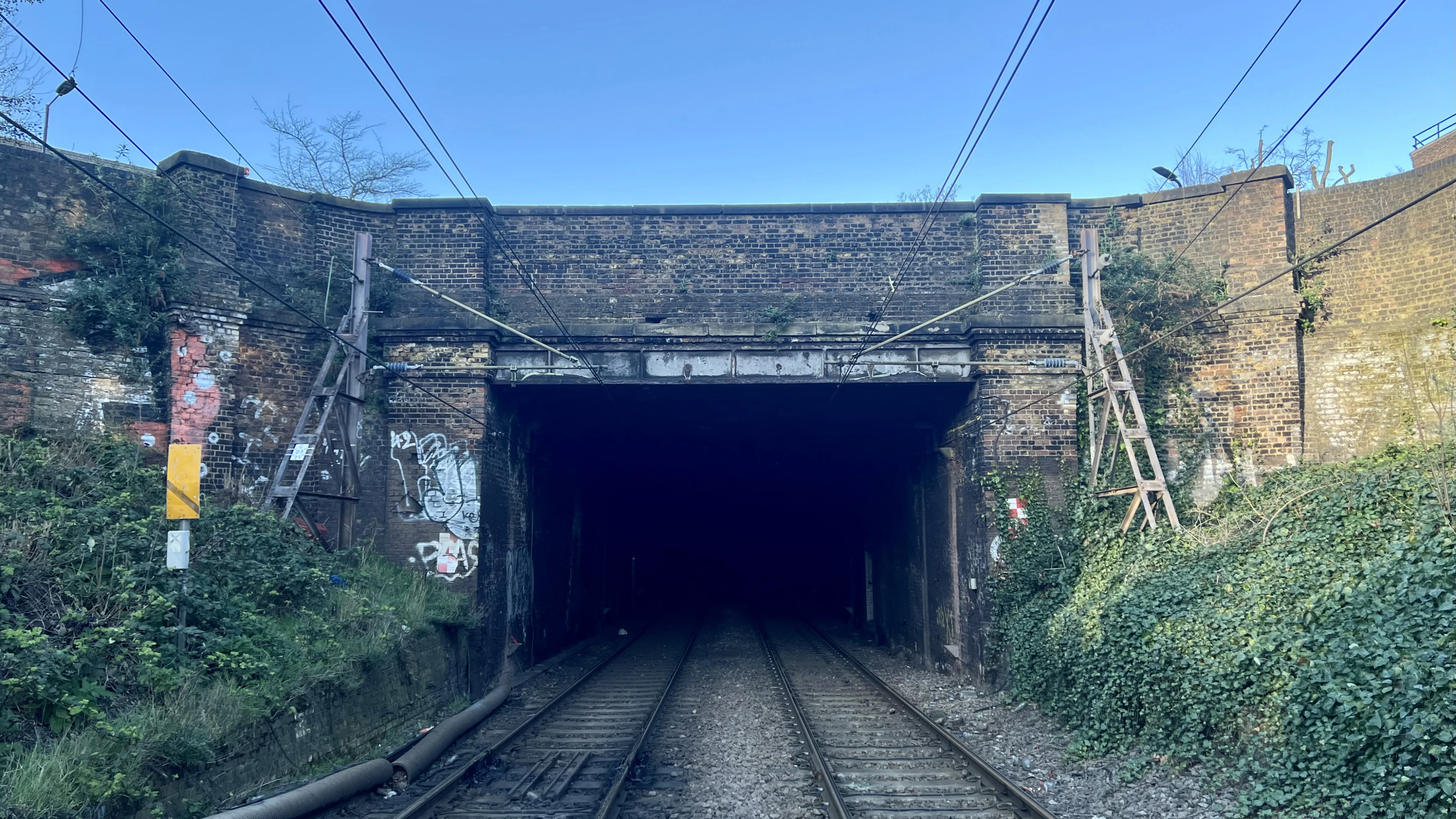 Photograph of an old bridge above railway tracks