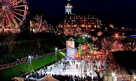 An outdoor ice skating rink and funfair at night, in the centre of Edinburgh. 