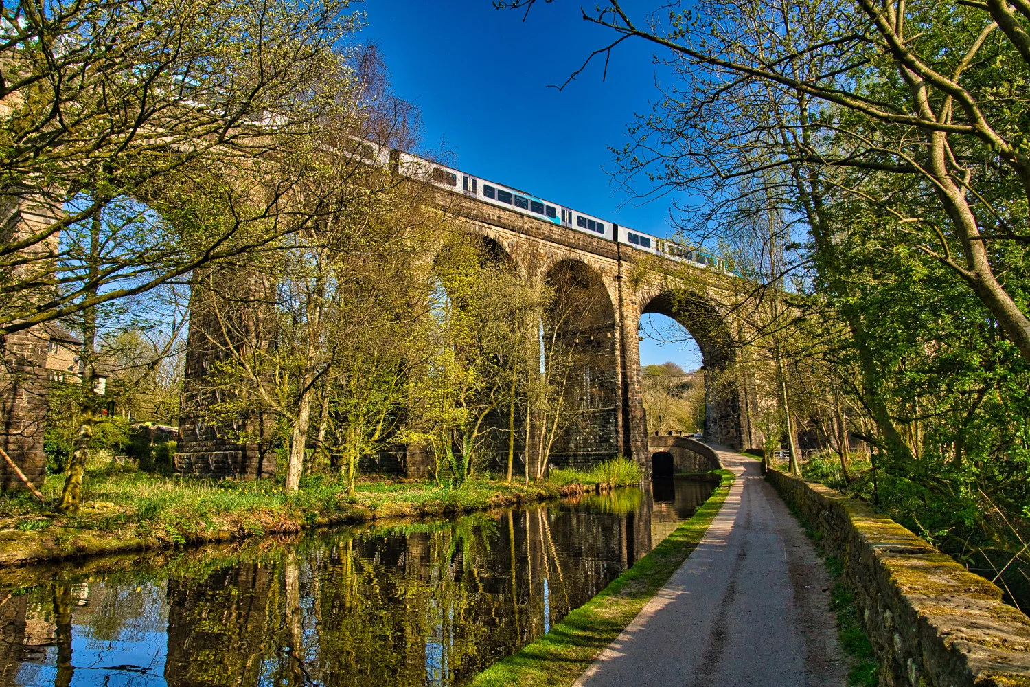 Arches of Saddleworth railway viaduct with train passing over, Uppermill, Saddleworth, Oldham, Greater Manchester, England