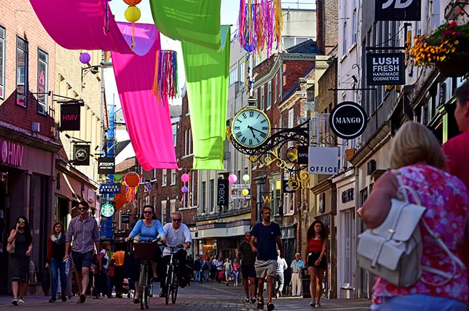People walking and cycling on a busy street in York.