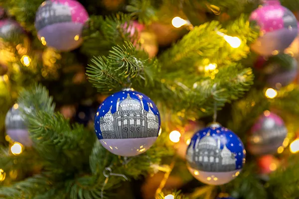 Close up of a Christmas tree with blue baubles that have an drawing of the Royal Pavilion on.