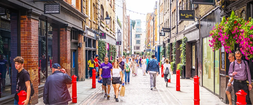 People walking down a busy pedestrian shopping street.