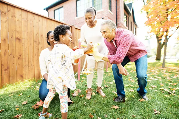 4 member of a multigenerational Black family playing outside on an autumn day. 