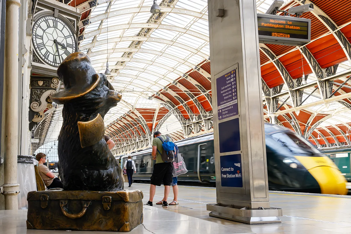 A platform at Paddington station with a bronze statue of Paddington Bear. 