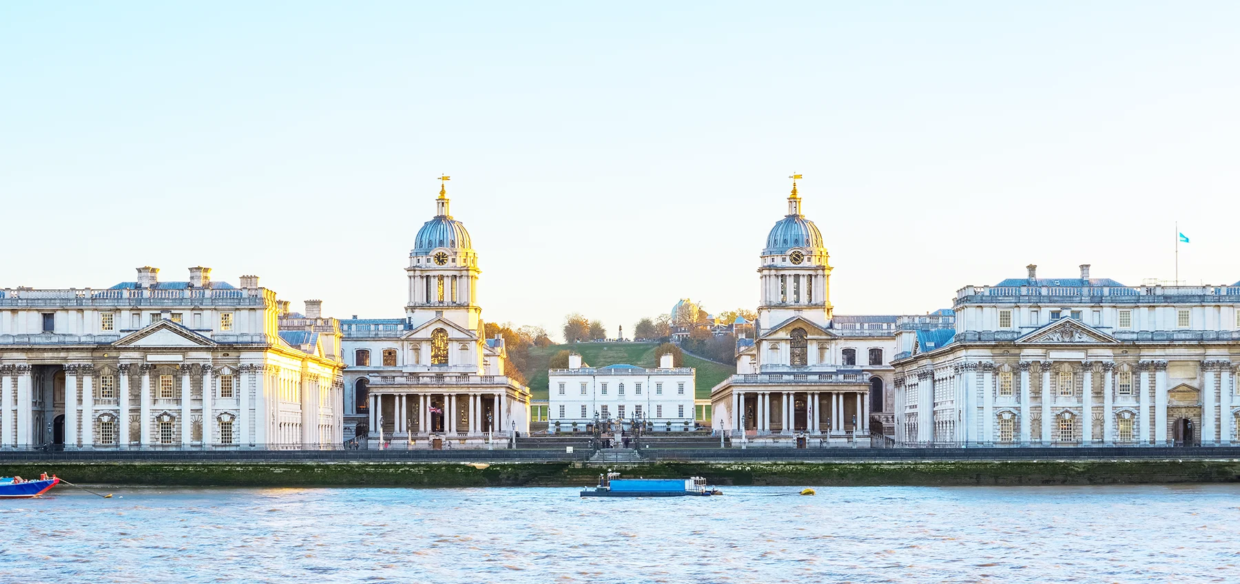 The River Thames at Greenwich with large white historic buildings on the riverside.
