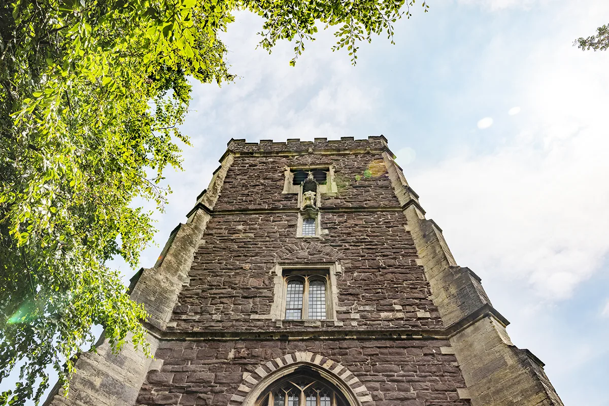 Looking up an an imposing brick cathedral tower. 
