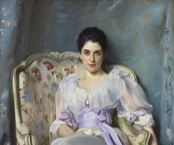 A painting of a woman in a pale dress with a violet sash, sitting in an armchair with floral upholstery 