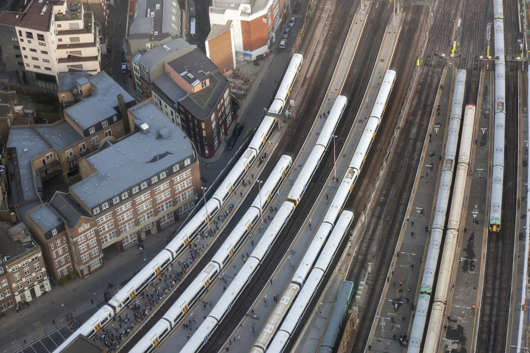 Aerial view of London Bridge Station with trains and commuters on platforms, London, horizontal orientation, England.