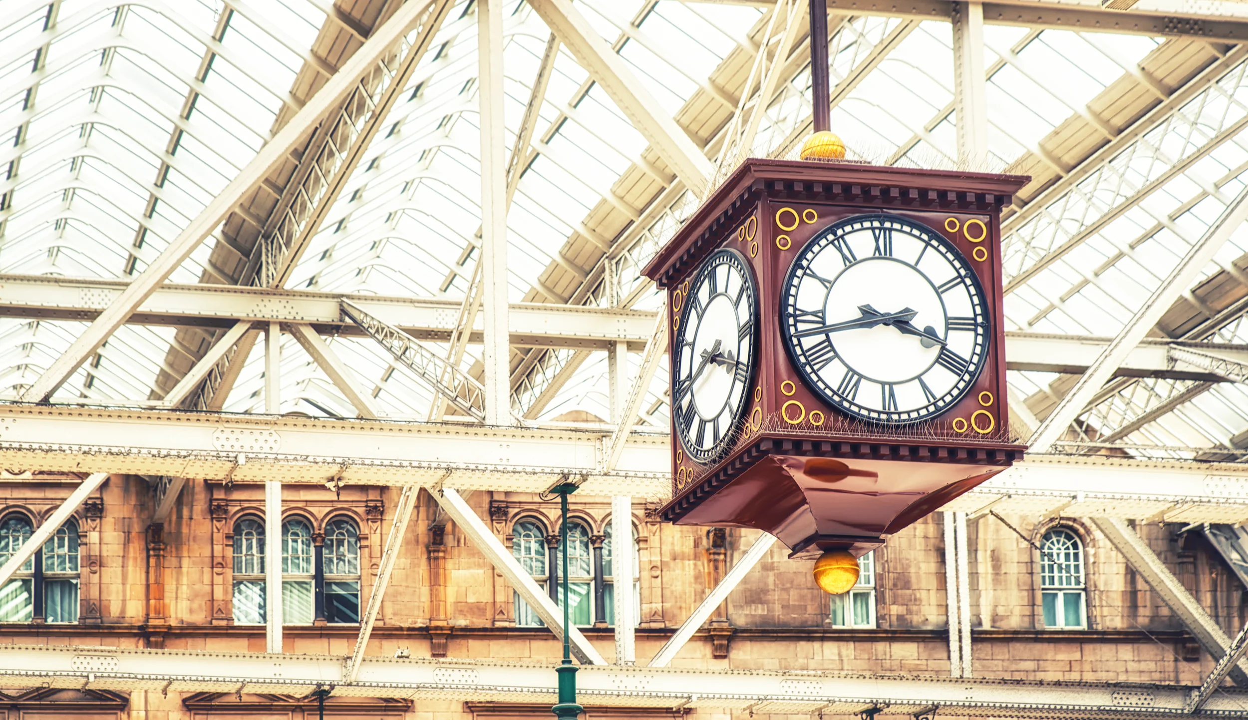 The four-sided hanging clock at Glasgow Central station on a sunny day