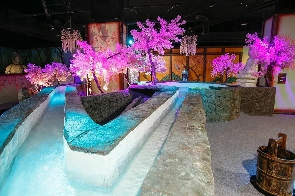 An indoor golf room decorated in a Japanese style with cherry blossom trees. 