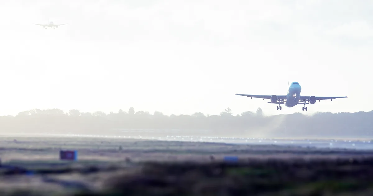A plane taking off from a runway in the daytime.