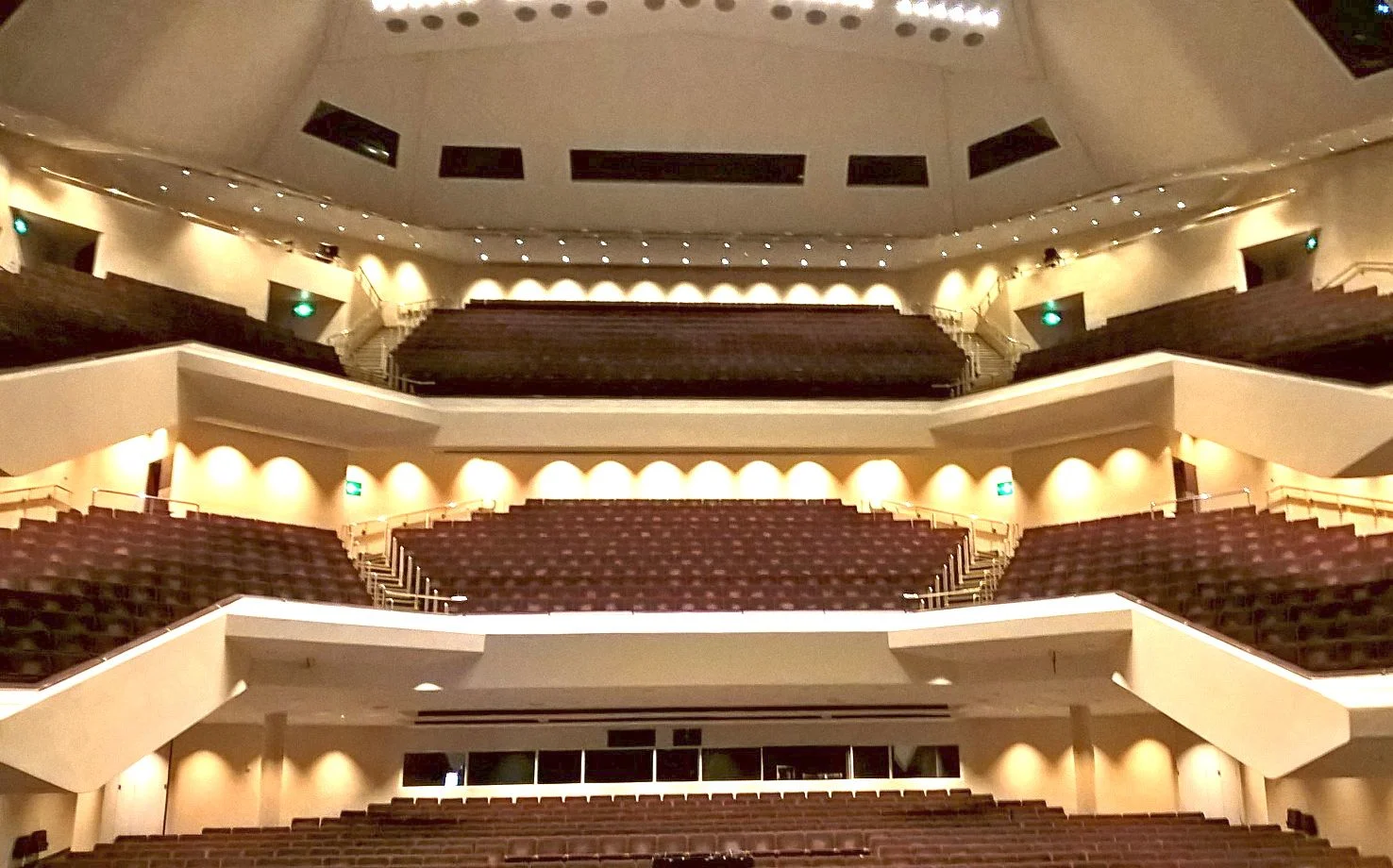 View of the empty seats of a concert hall with 3 levels. 