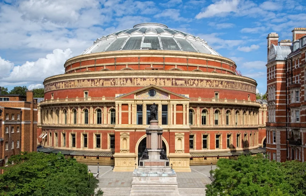 London's Albert Hall concert venue – a large, circular red brick building with a glass dome on top.