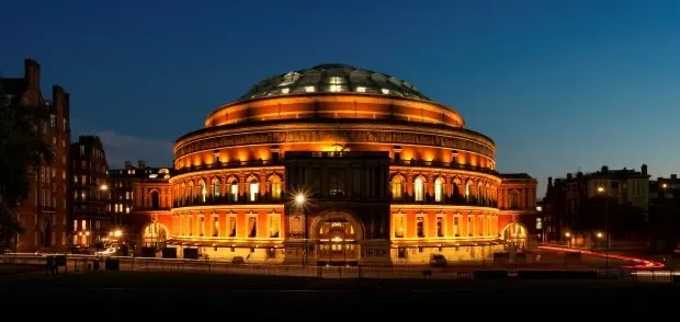 Royal albert hall lit up against the blue evening sky of London