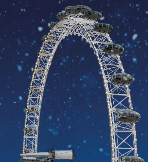 The London Eye against a dark night sky with snow falling.