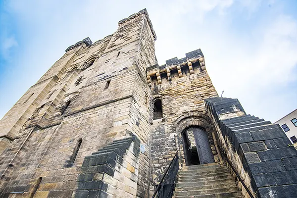 Looking up at an ancient stone castle.