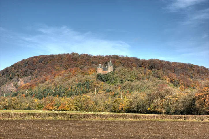 Castell Coch in Cardiff, an isolated castle on a hillside surrounded by autumn trees 