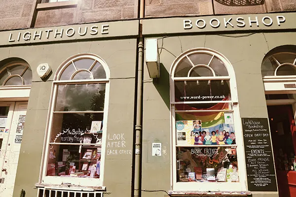 The exterior of a bookshop with arched windows displaying books.