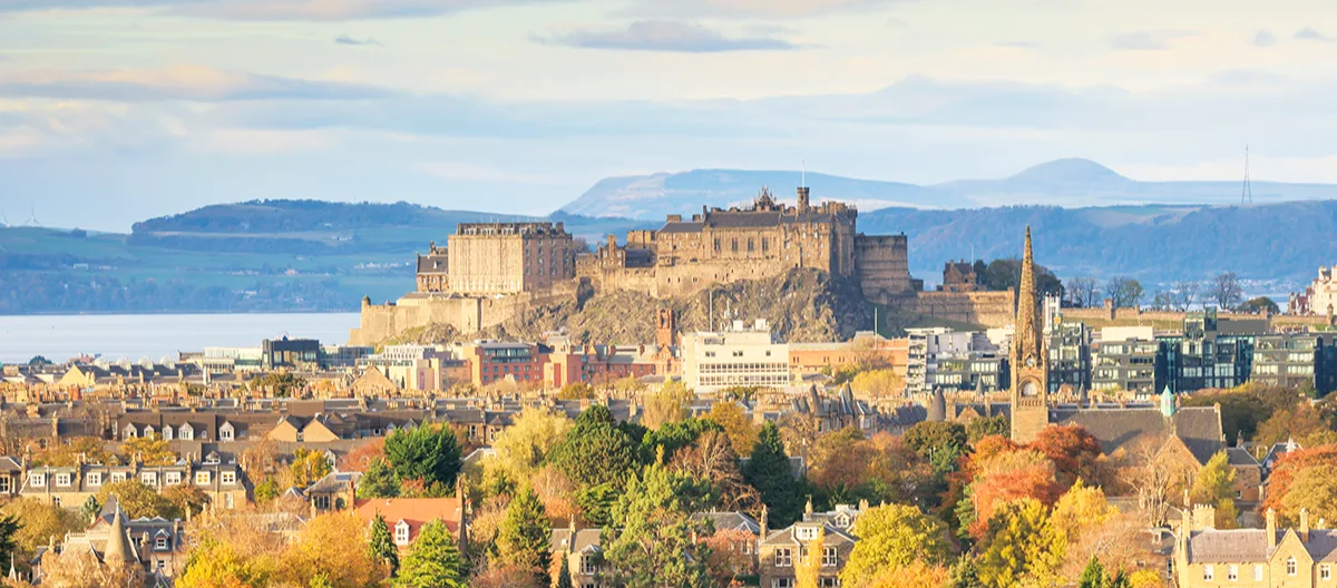 The city of Edinburgh on a sunny autumn day, looking across the city to the castle on the hill.