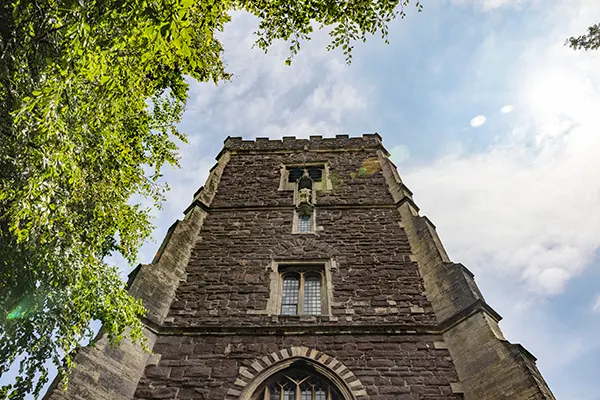 Looking up an an imposing brick cathedral tower. 