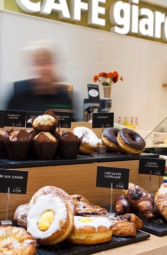 A display of doughnuts and pastries in a cafe.