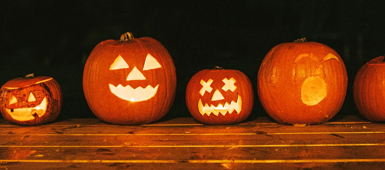 A night time scene of a selection of Halloween pumpkins lit from inside with candles