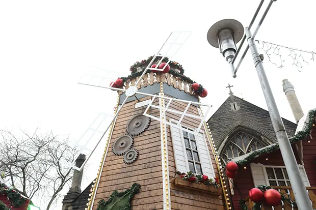 A wooden windmill with festive decorations. 