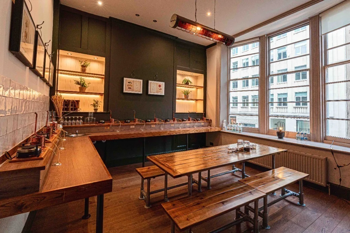A room with wooden benches and scientific equipment for distilling alcohol. 