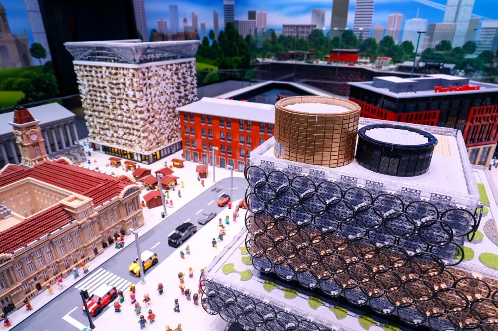 A Lego city with tall buildings and Lego figures on the streets.