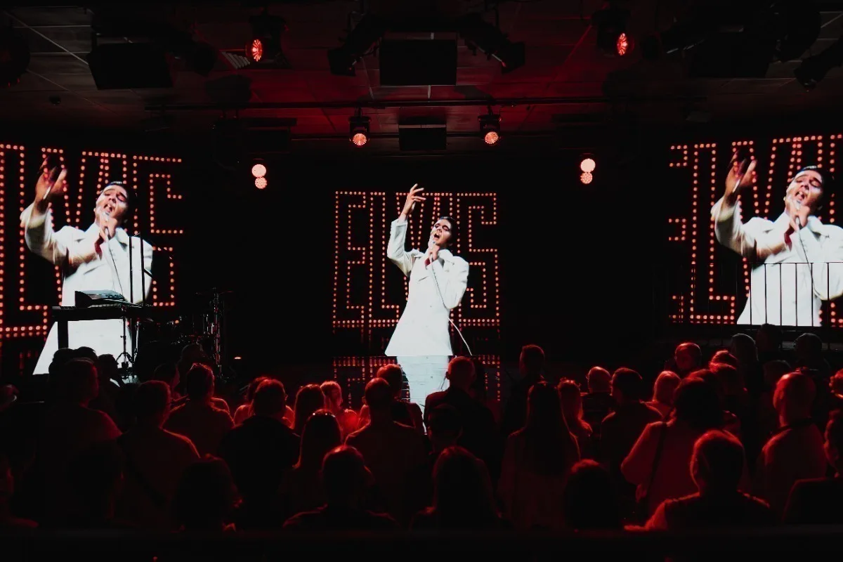 Images of Elvis Presley in a white suit on stage with dramatic red lighting and video screens, watched by an audience.